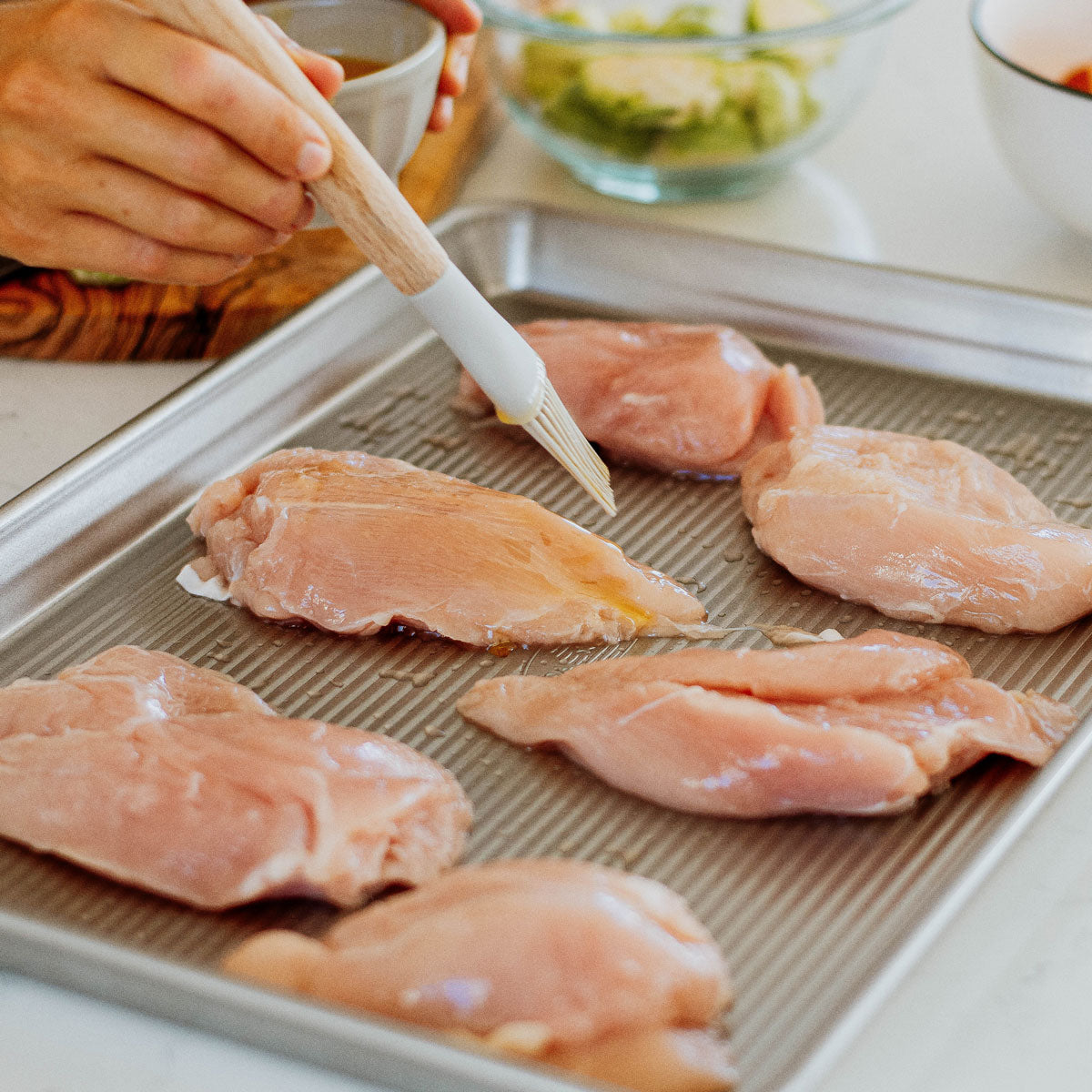 organic raw chicken breasts on a sheet pan