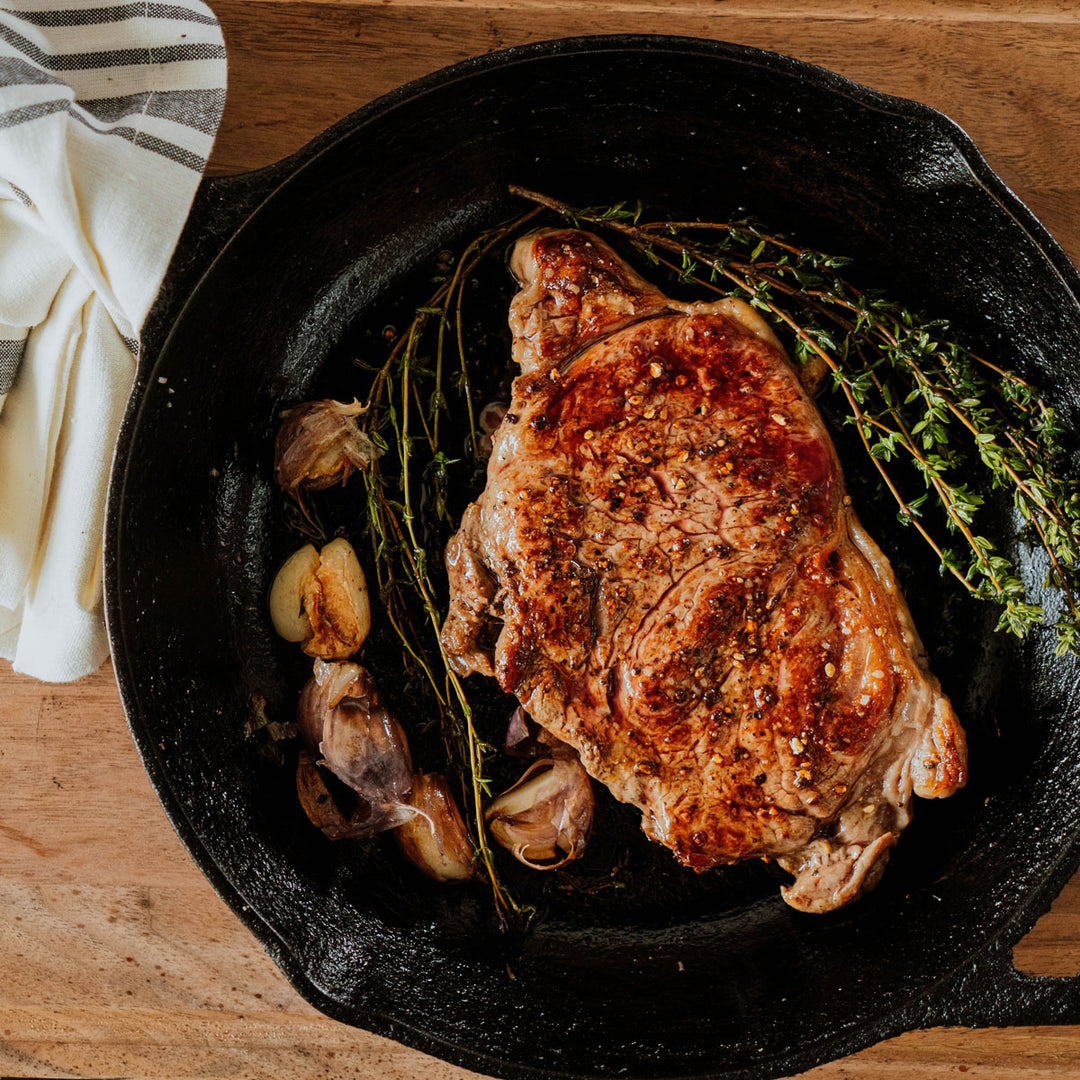 new york strip steak in a cast iron with thyme and garlic