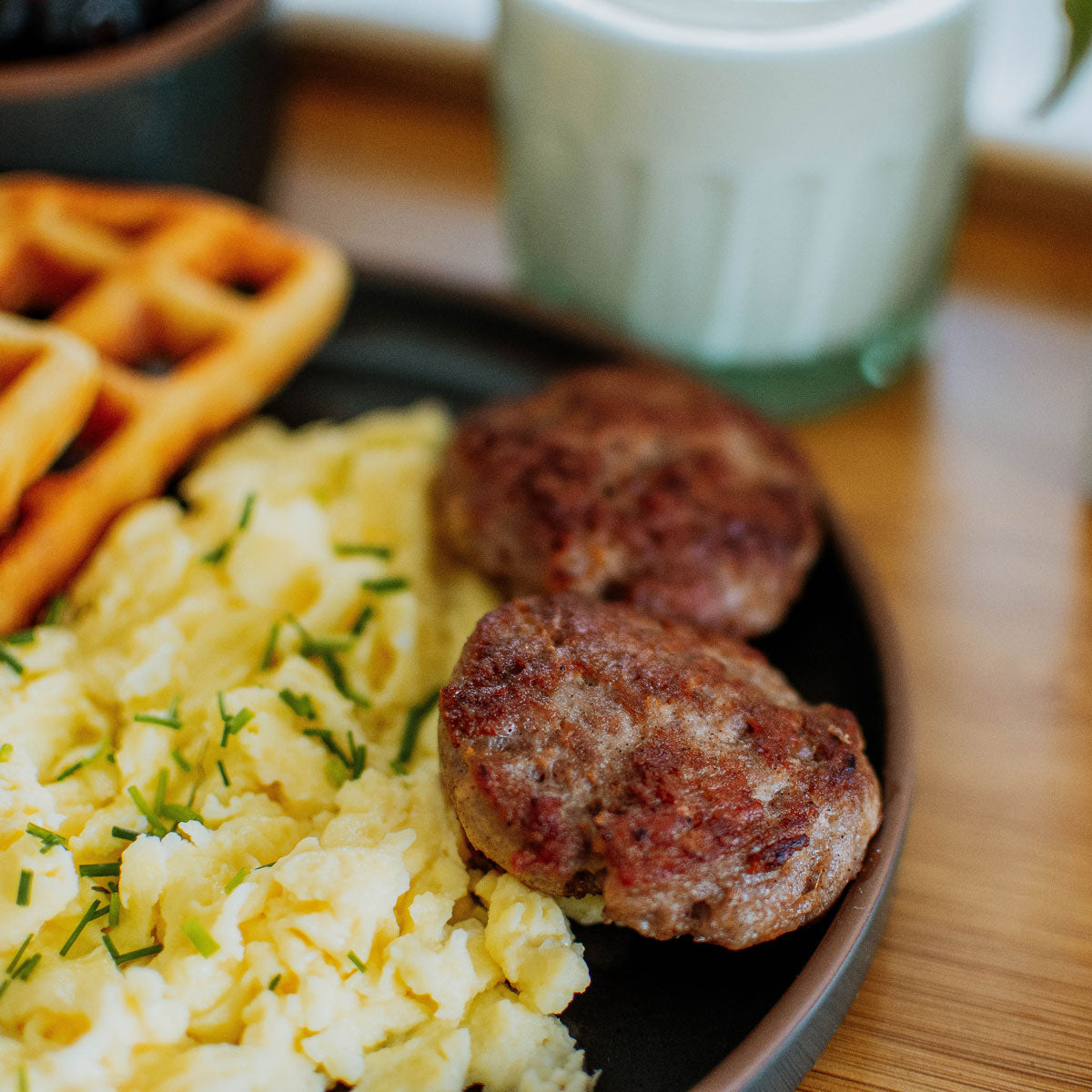 organic pork breakfast sausage on a plate with eggs and waffles